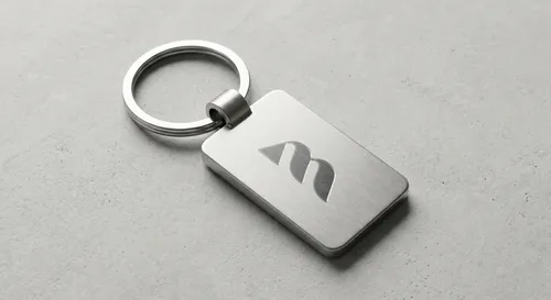 Free Metallic Keychain Mockup On Concrete — Engraved Logo (PSD) mockup preview